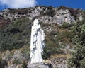 A white statue of the Virgin Mary praying along the Amalfi Coast